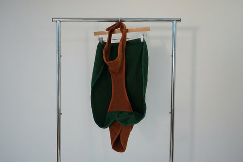 Green and brown garment on a hanger against a white background